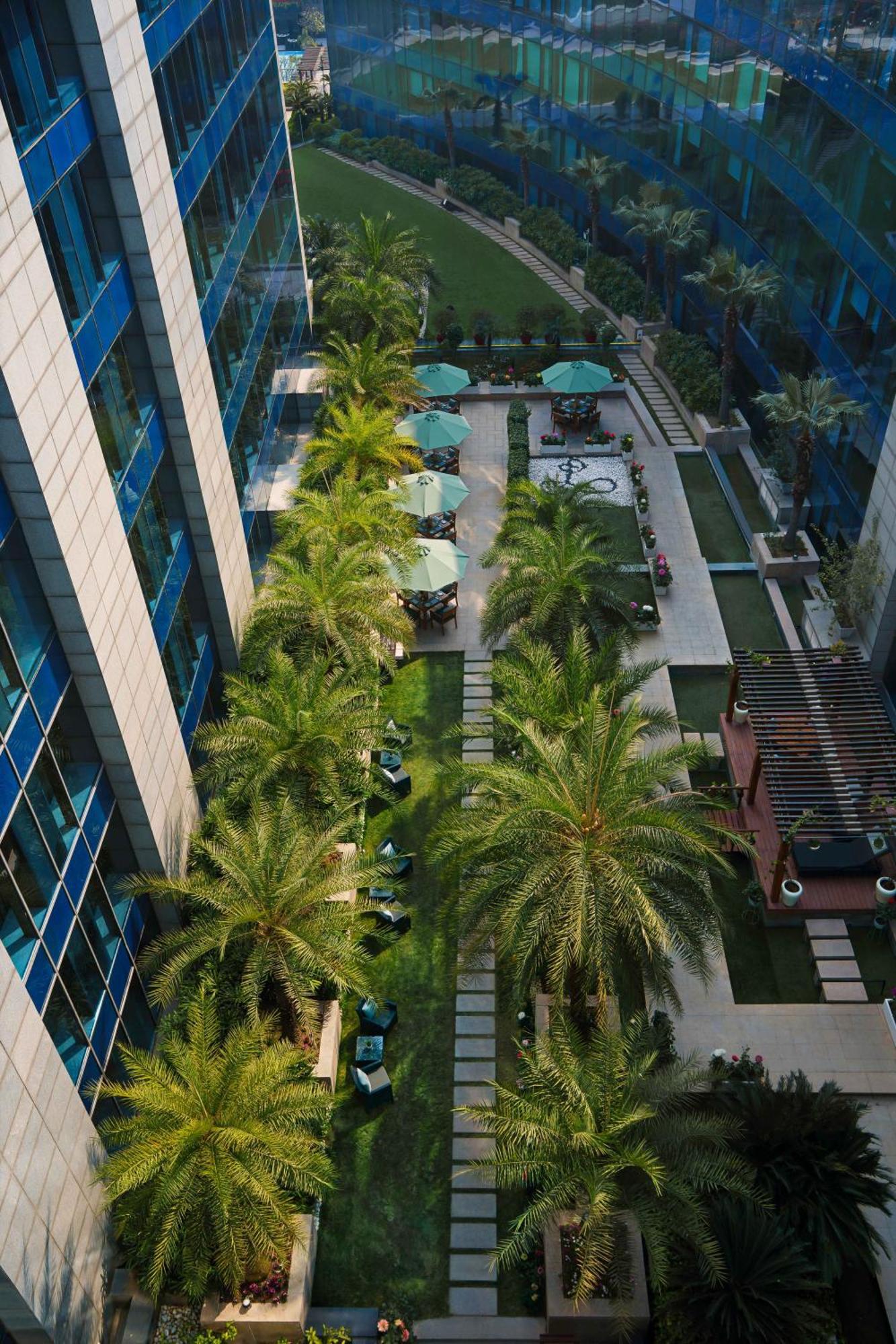 เดอะ ลีลา แอมเบียนซ์ โฮเต็ล แอนด์ เรสซิเดนซ์ คุรุคราม Hotel คูร์เคาน์ ภายนอก รูปภาพ The courtyard of the hotel